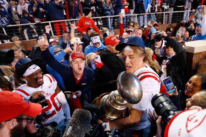 Nov 23, 2023; Starkville, Mississippi, USA; Mississippi Rebels quarterback Jaxson Dart (2) shares the Egg Bowl trophy with fans after defeating the Mississippi State Bulldogs at Davis Wade Stadium at Scott Field. Mandatory Credit: Petre Thomas-USA TODAY Sports